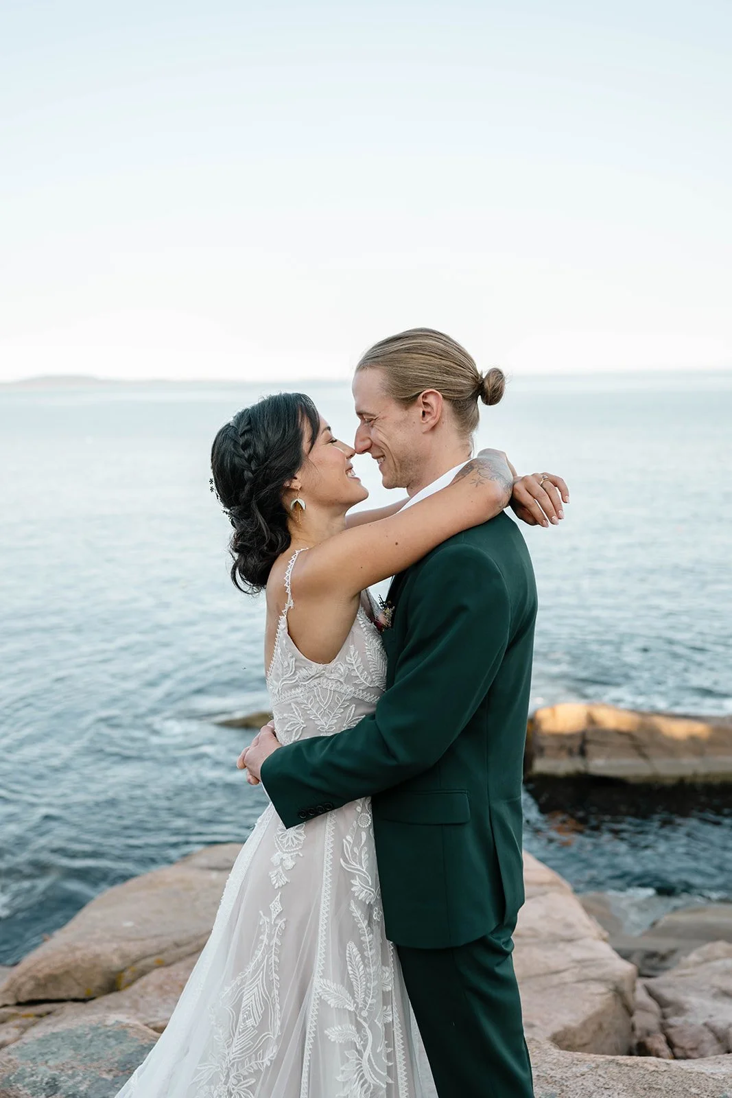 bride and groom hugging on a cliff during their acadia elopement