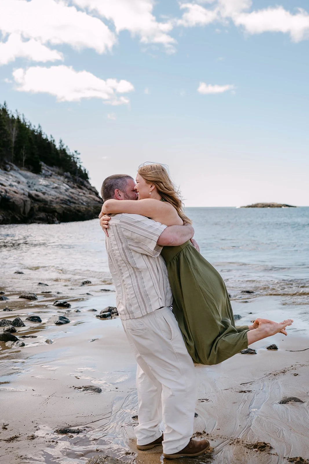 playful couple during their acadia national park engagement photos session at the coast of sand beach