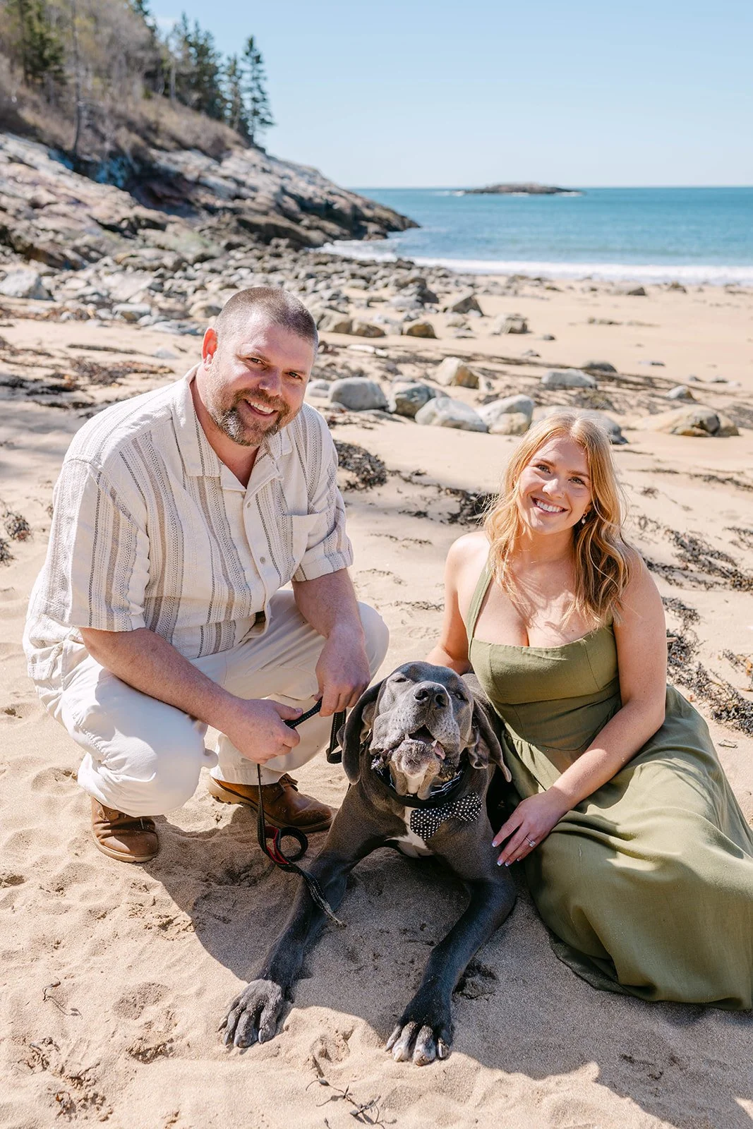 couple and their dog during their engagement session at Sand Beach in Acadia