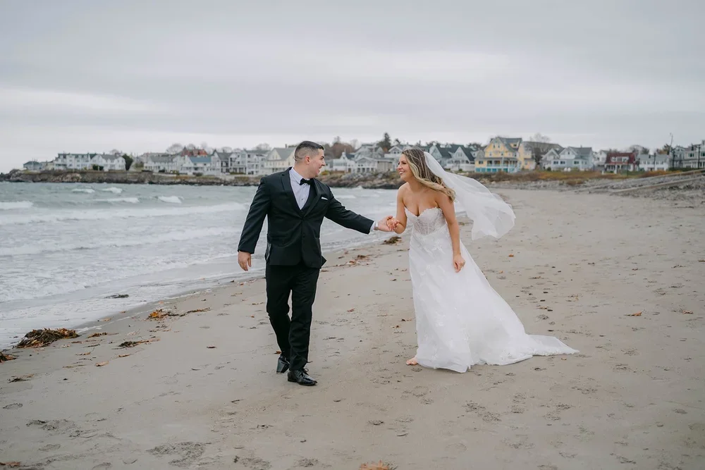 elopement couple running hand in hand along the beach in acadia