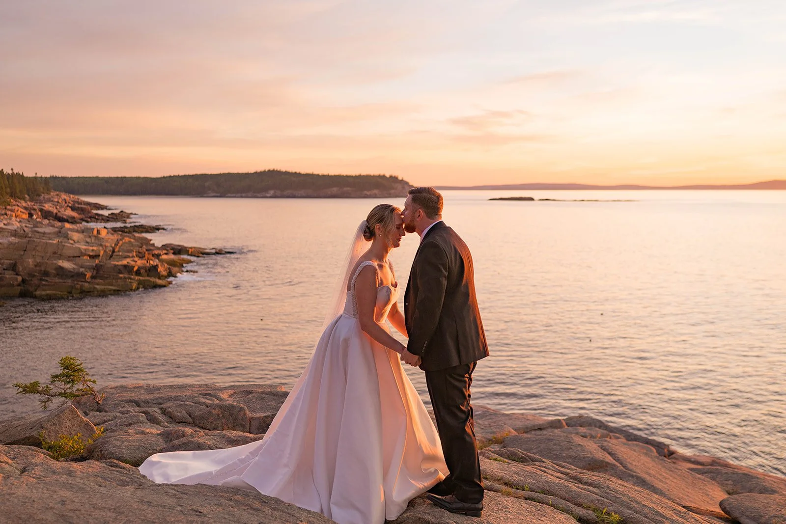 groom kissing bride on the forehead during an acadia national park elopement