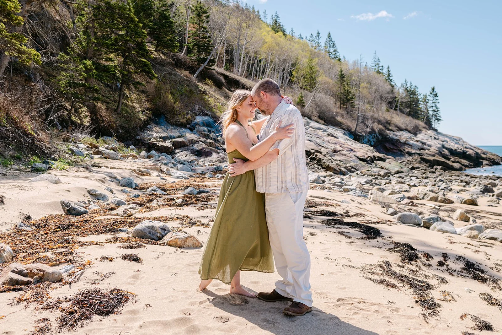 playful couple during their acadia national park engagement photos session at sand beach