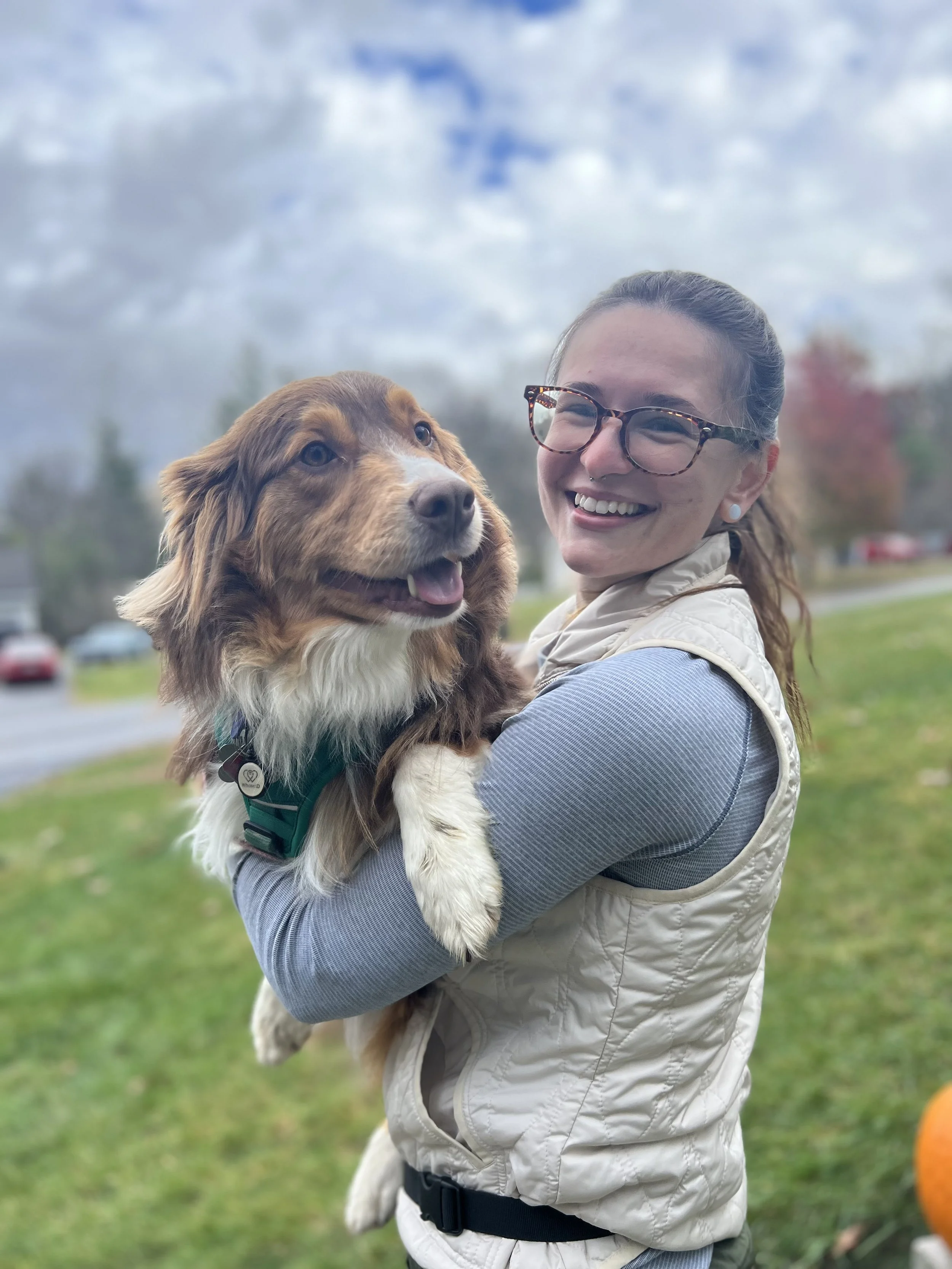 Cassie smiling while holding her dog Penelope