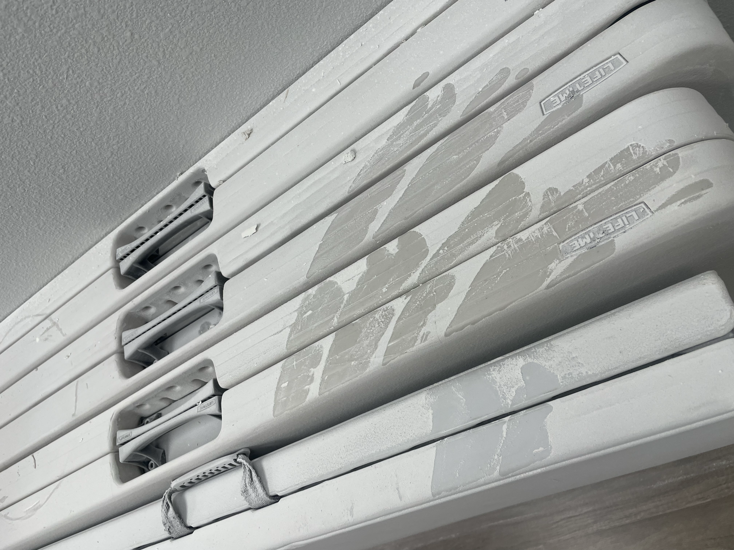 Close-up of white window blinds with paint splatter on them.