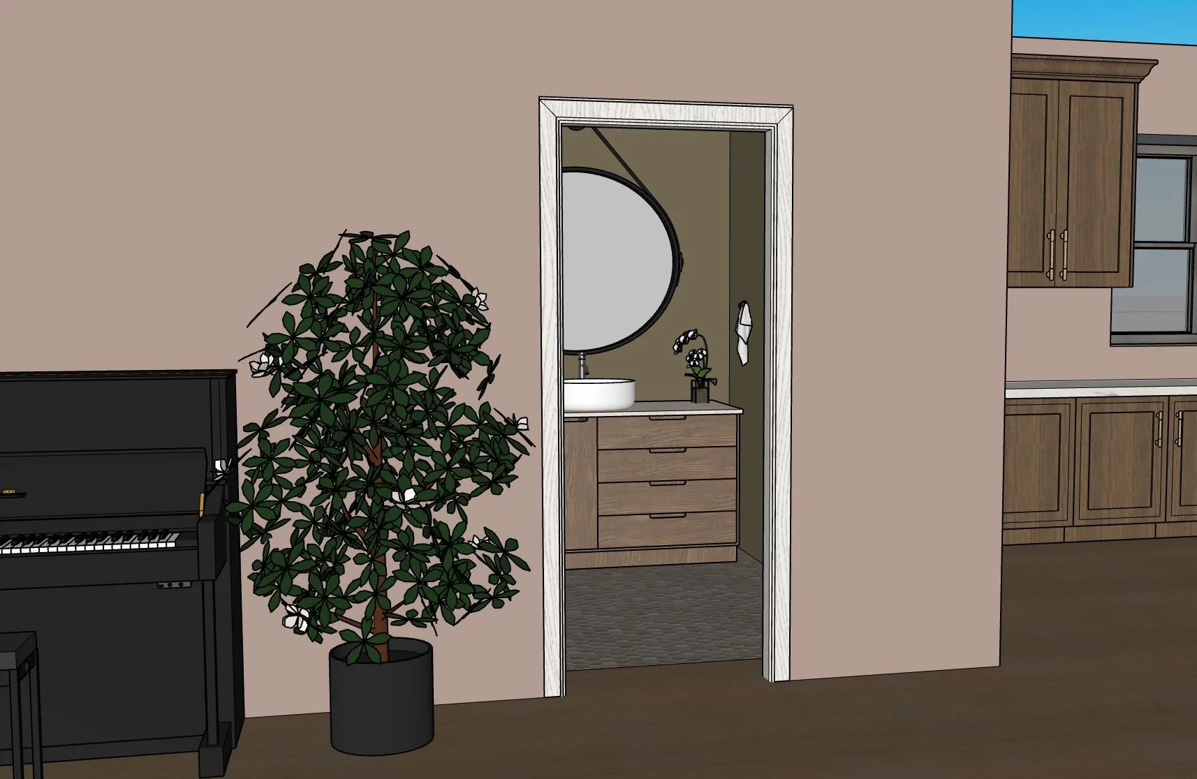Interior view showing a doorway leading to a bathroom with a wooden vanity, round mirror, sink, and small decorative flowers. To the left, a tall potted plant, next to a black upright piano. To the right, part of a kitchen with wooden cabinets and a 