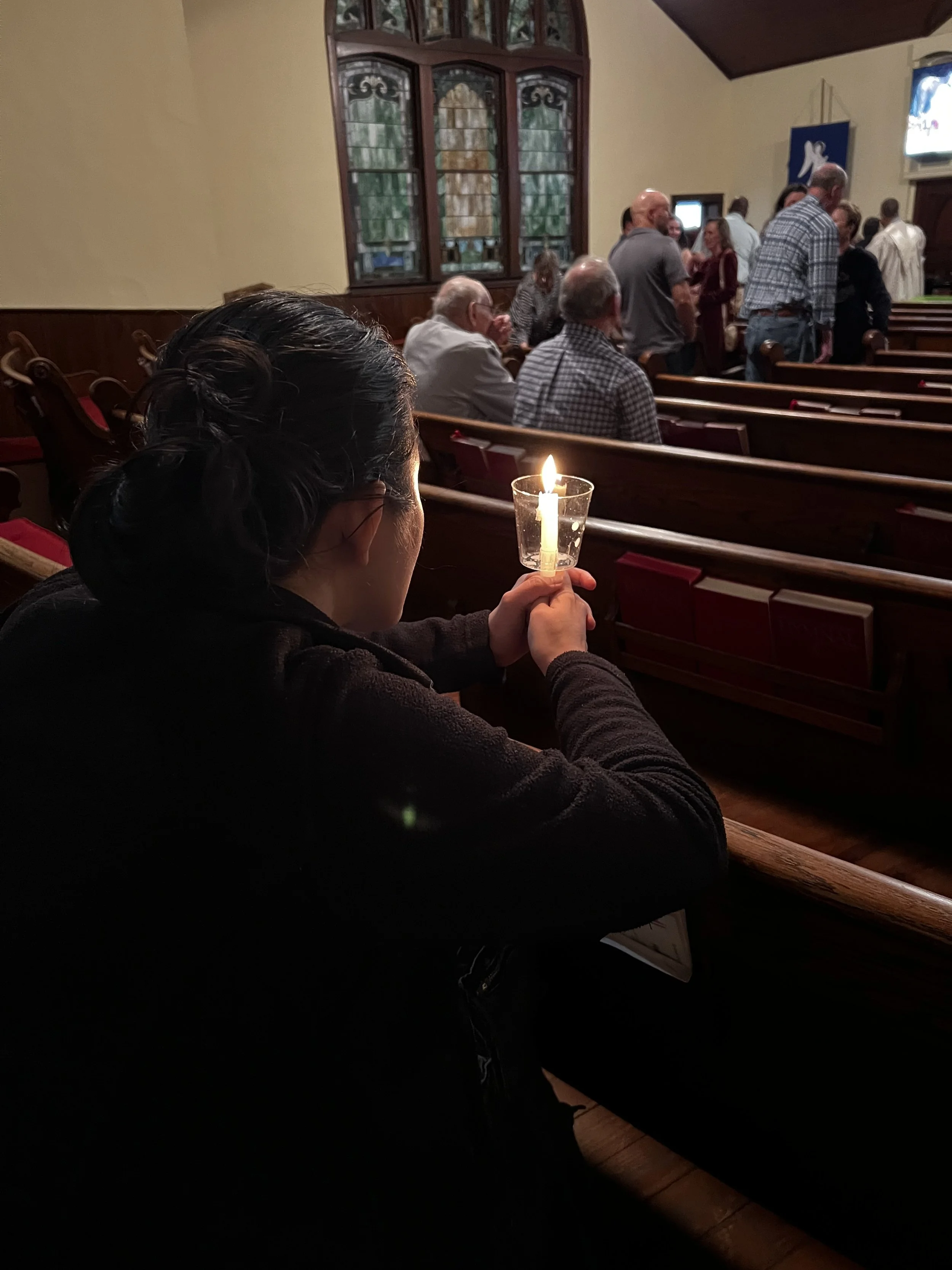 woman holding candle while in prayer