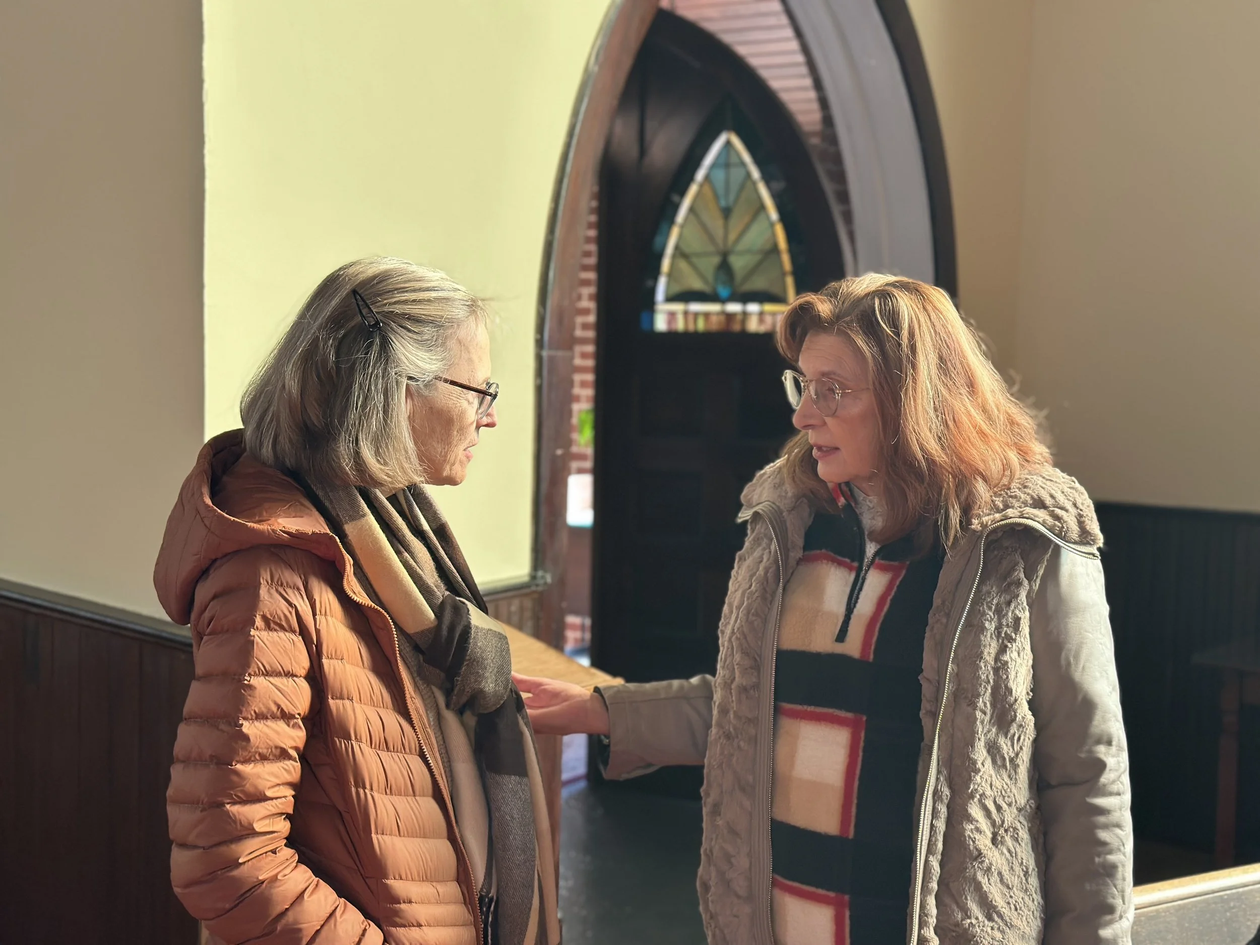 Two women in conversation in the church sanctuary