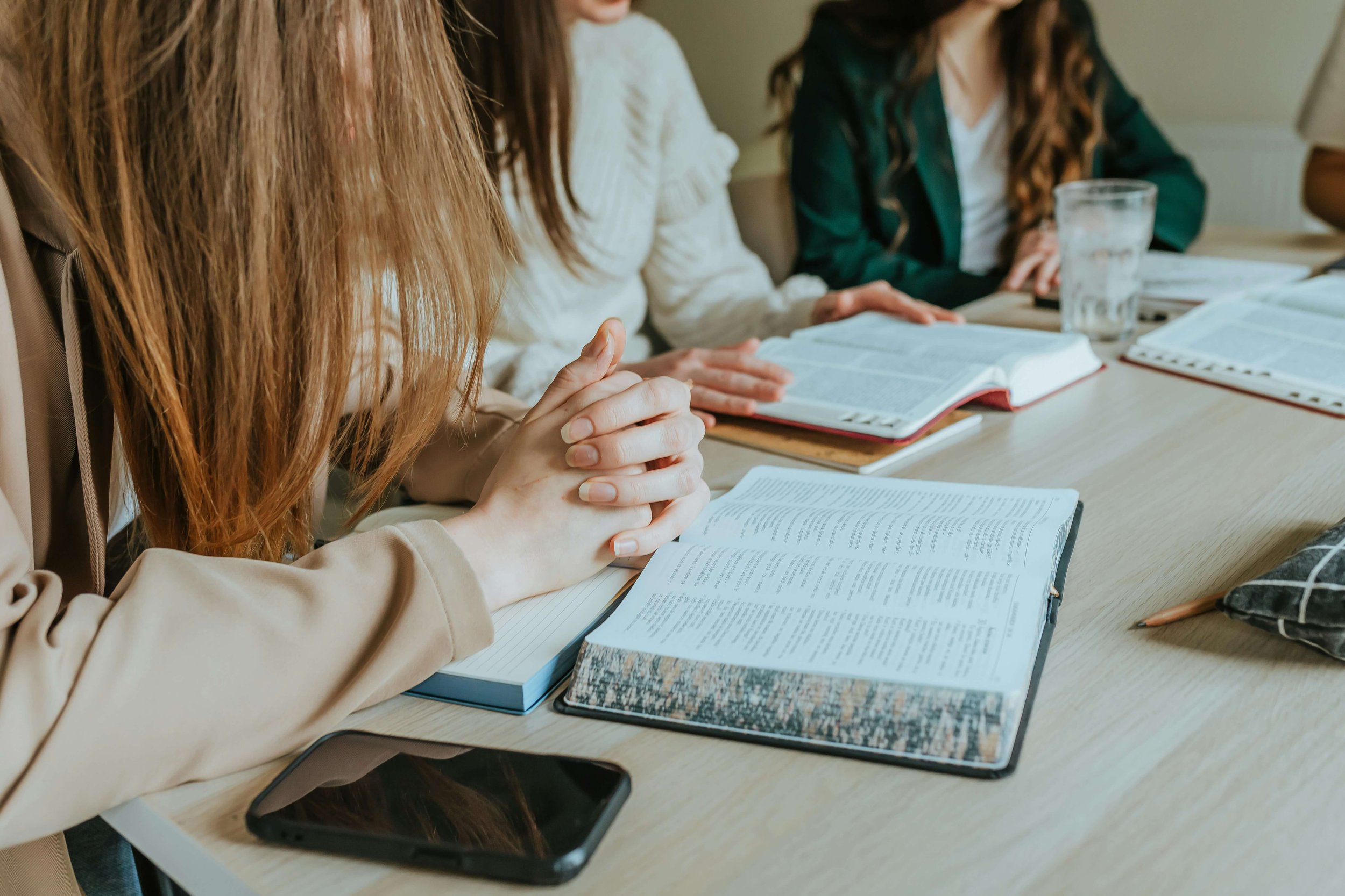 women sitting with bibles in front of them.