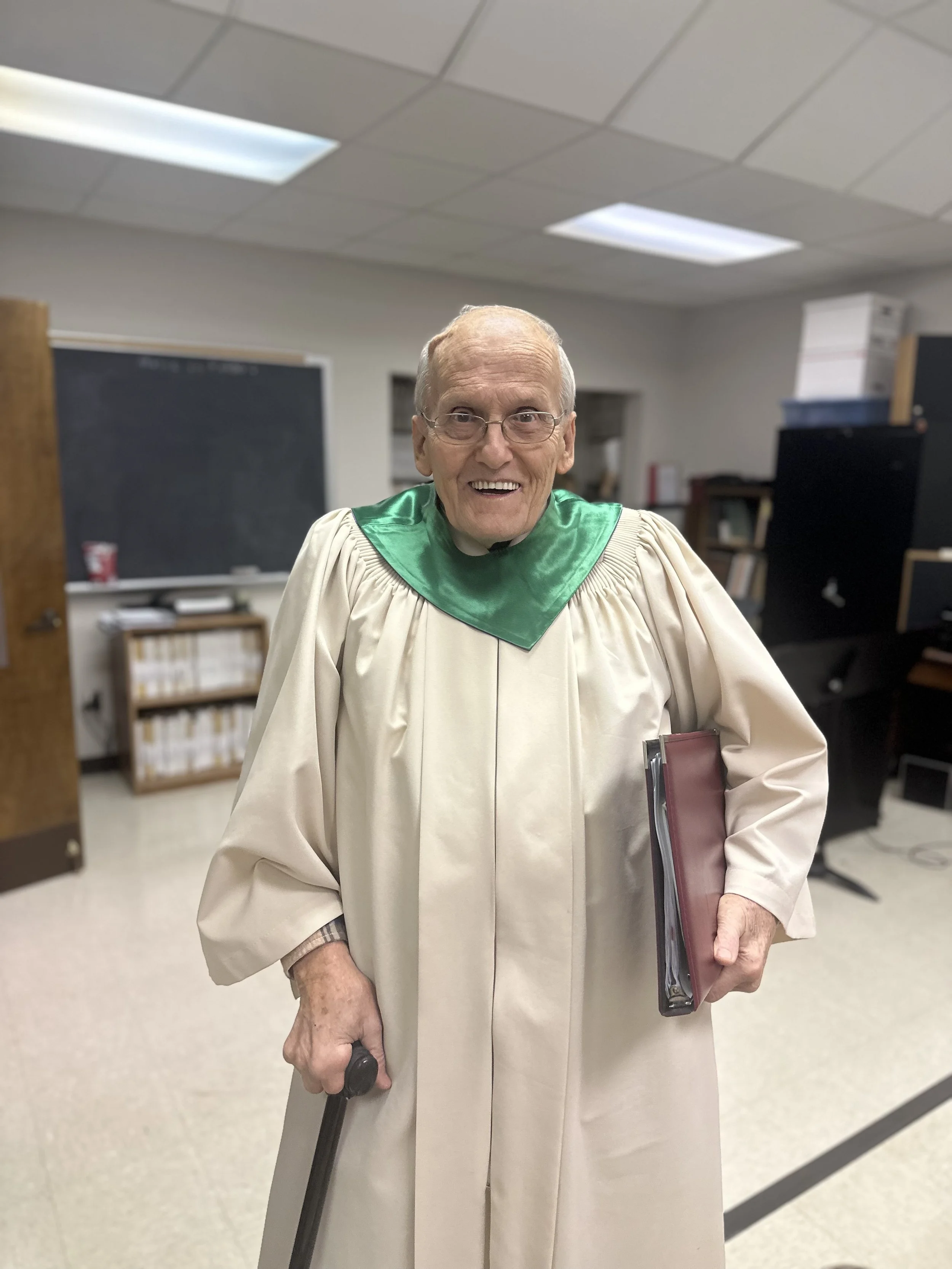 smiling male church member with his choir robe on