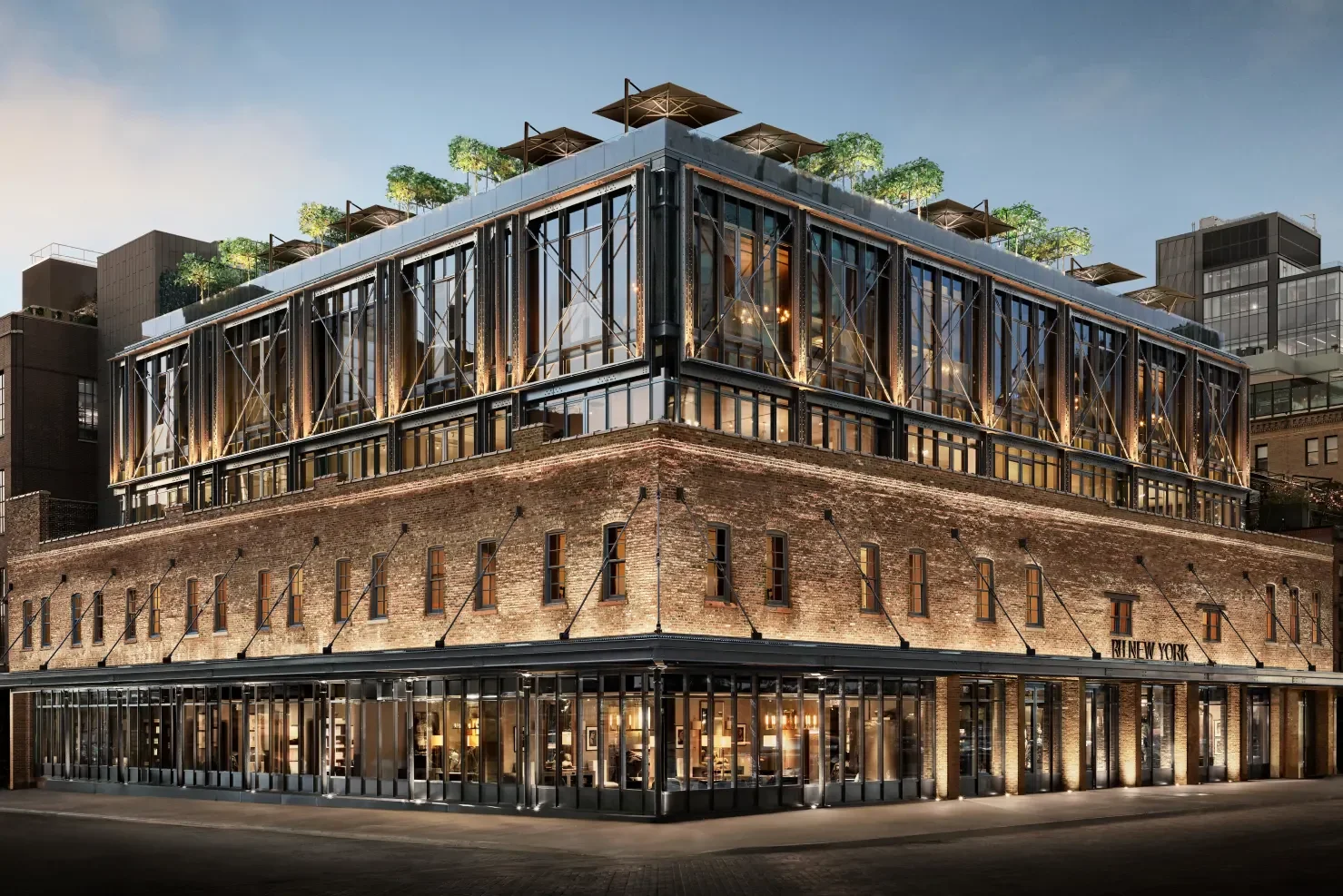 Urban building at dusk with brick base and glass upper levels, featuring rooftop greenery and umbrellas.
