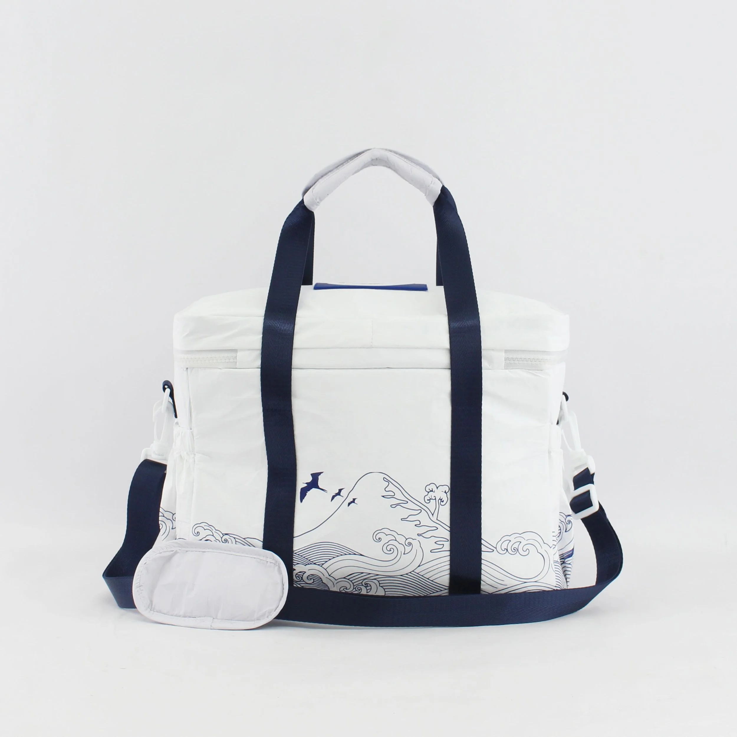 White tote bag with navy blue straps and wave design, accompanied by a small matching pouch, against a white background.