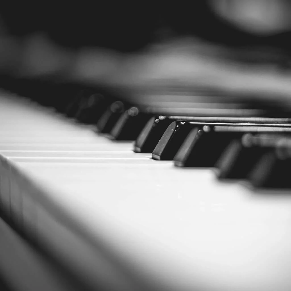Close-up of a piano keyboard in black and white, showing black and white keys.