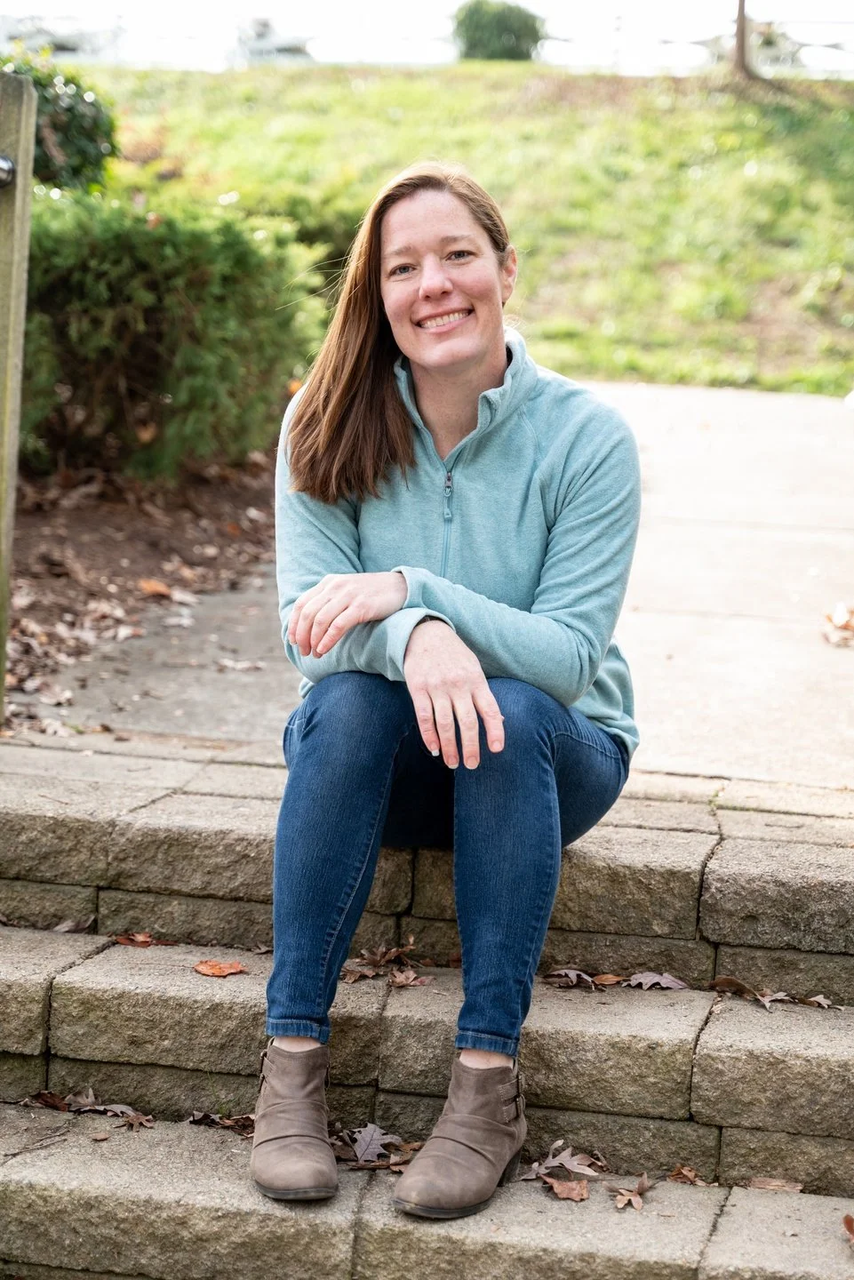Certified past life regression and Life Between Lives hypnotherapist and hypnotherapy certification instructor sitting on steps in an outdoor park