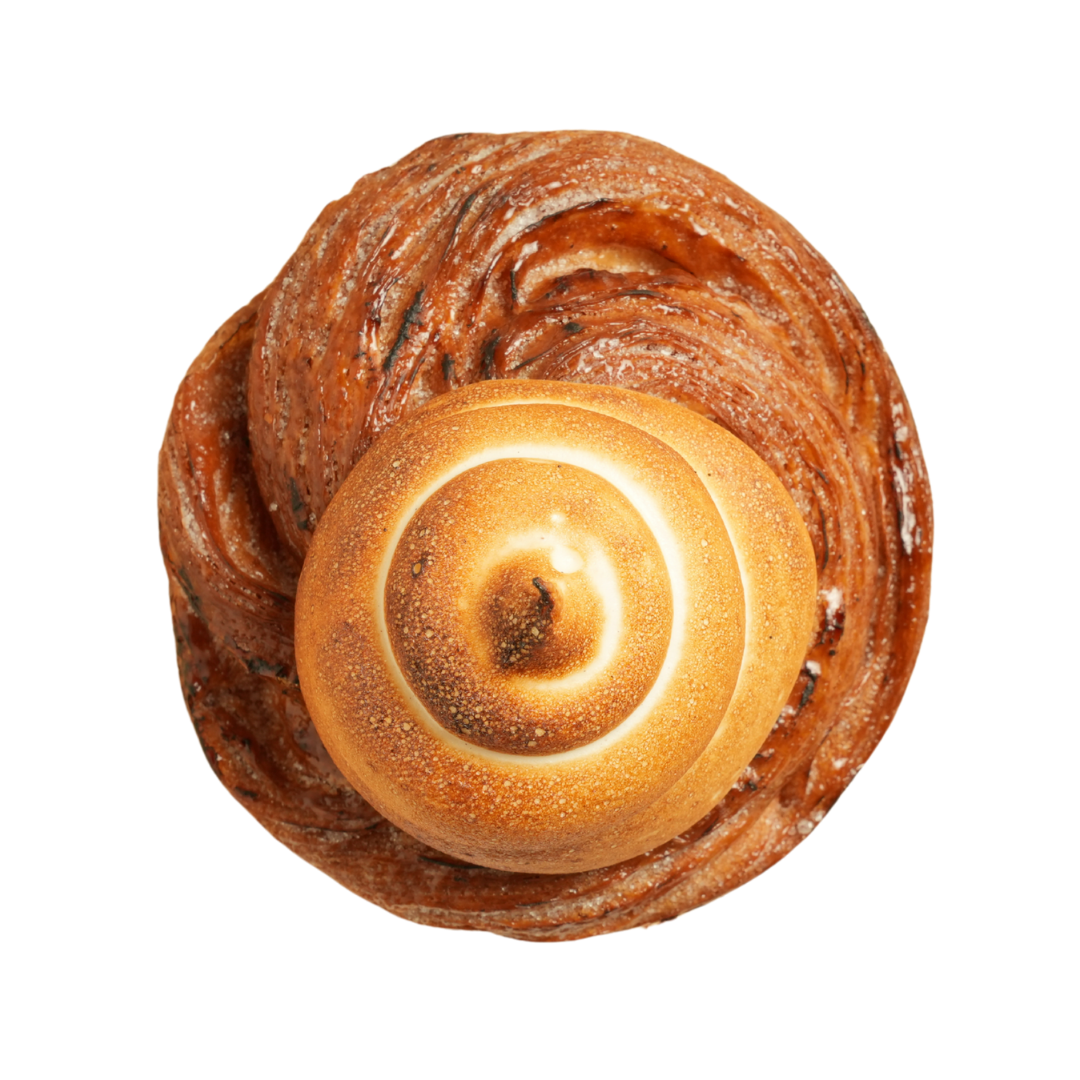 A top view of a cinnamon roll with a smaller, toasted bread roll placed in the center.
