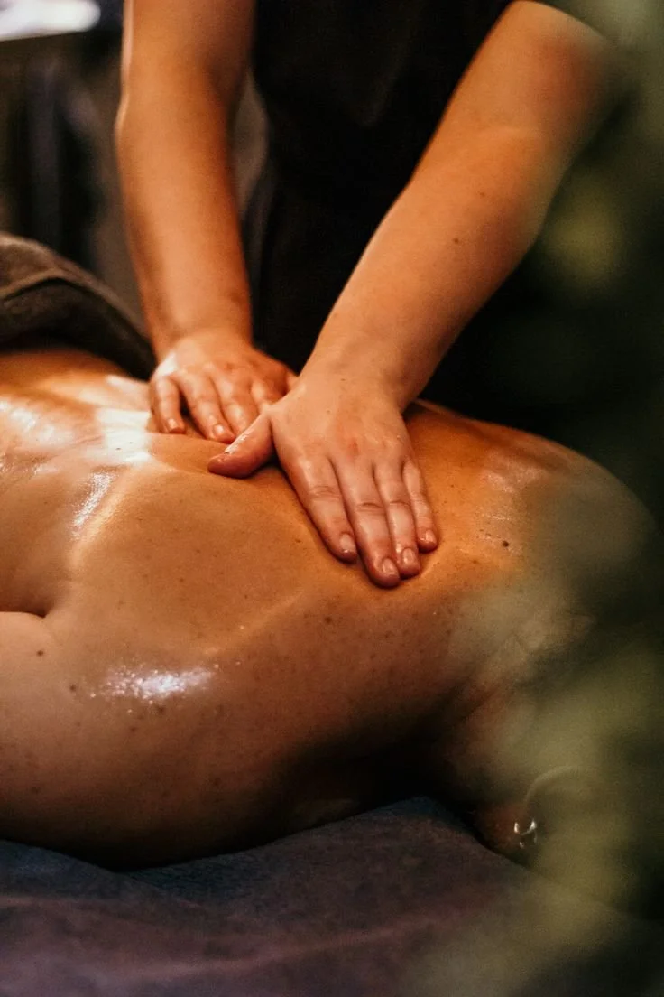Persona recibiendo un masaje en la espalda en un entorno de spa o bienestar.