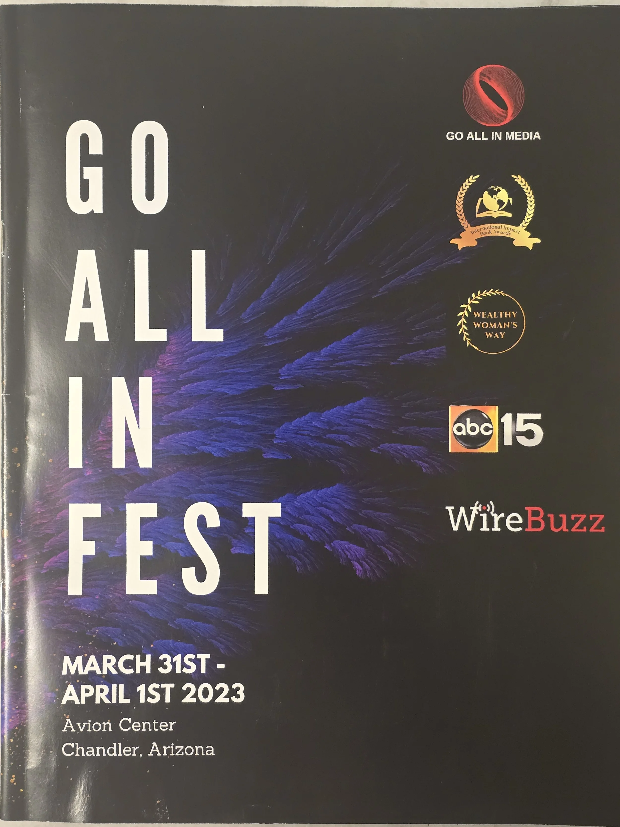Event poster for 'Go All In Fest' held from March 31st to April 1st, 2023 at Avion Center in Chandler, Arizona, featuring logos of media and awards, with a dark background and purple feather graphic.
