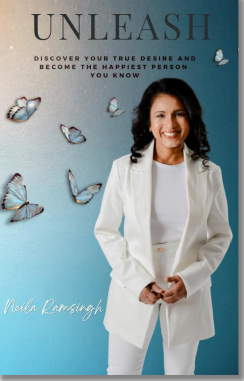 Book cover titled 'Unleash' featuring a smiling woman in a white suit, with butterflies flying around her, and the subtitle 'Discover your true desire and become the happiest person you know' written at the top. The author's name, Neil Ramsingh, is in cursive at the bottom.