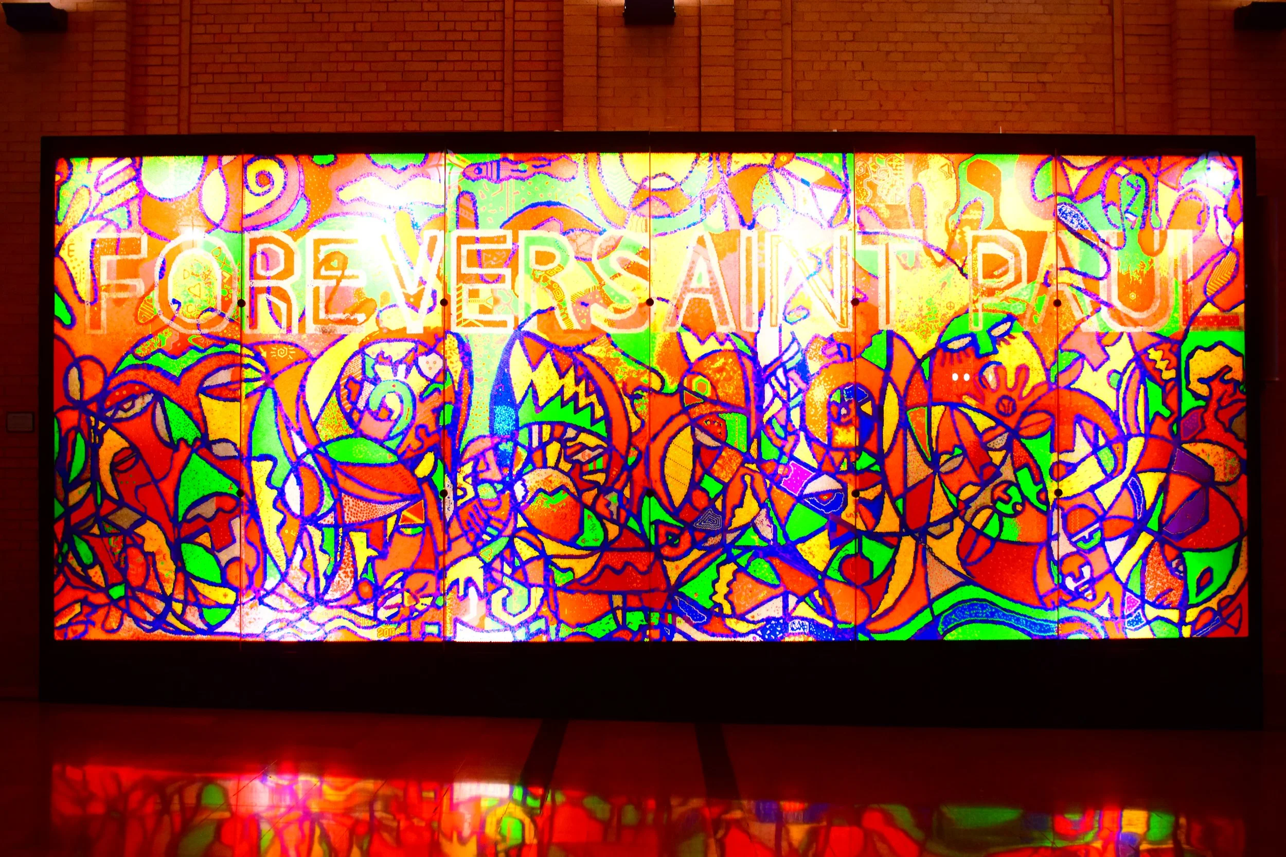 A brightly colored abstract mural with graffiti-style designs and the word 'FOREVERSAINT' in large white letters.