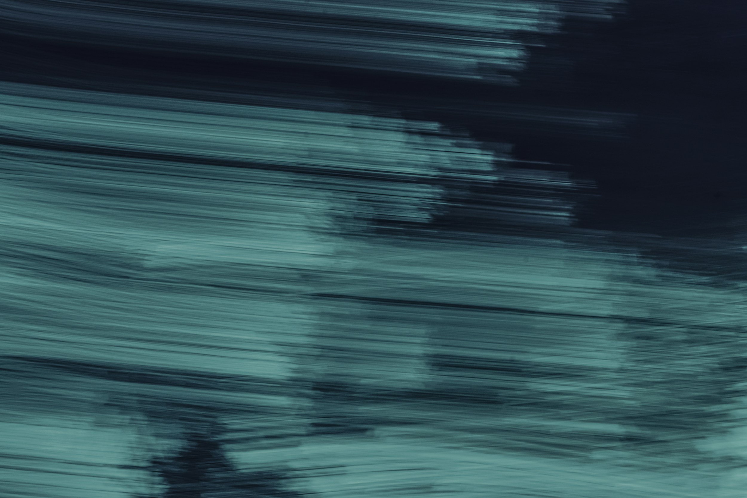 Abstract image with motion blur, showing streaks of dark and light blue colors.