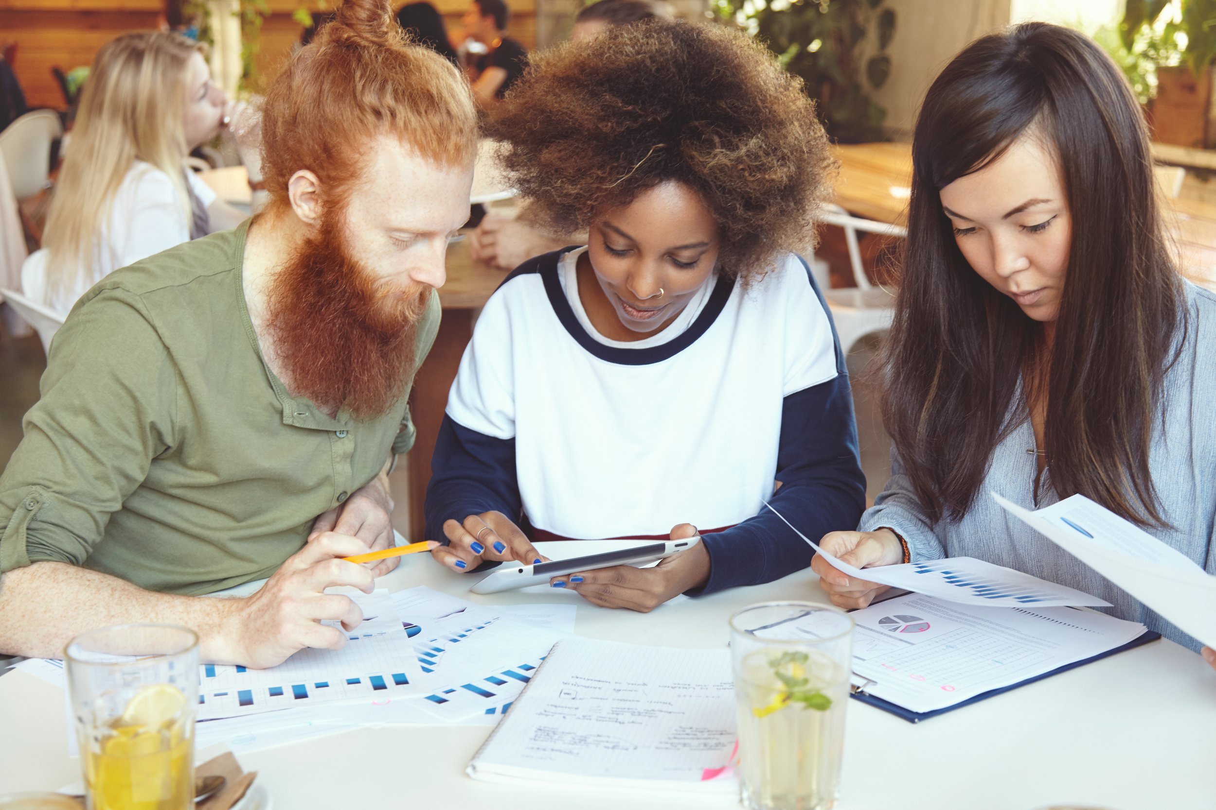 team-marketing-experts-developing-business-strategy-cafe-african-woman-presenting-business-plan-her-partner-with-red-beard-digital-tablet-while-their-asian-colleague-analysing-graphs.jpg