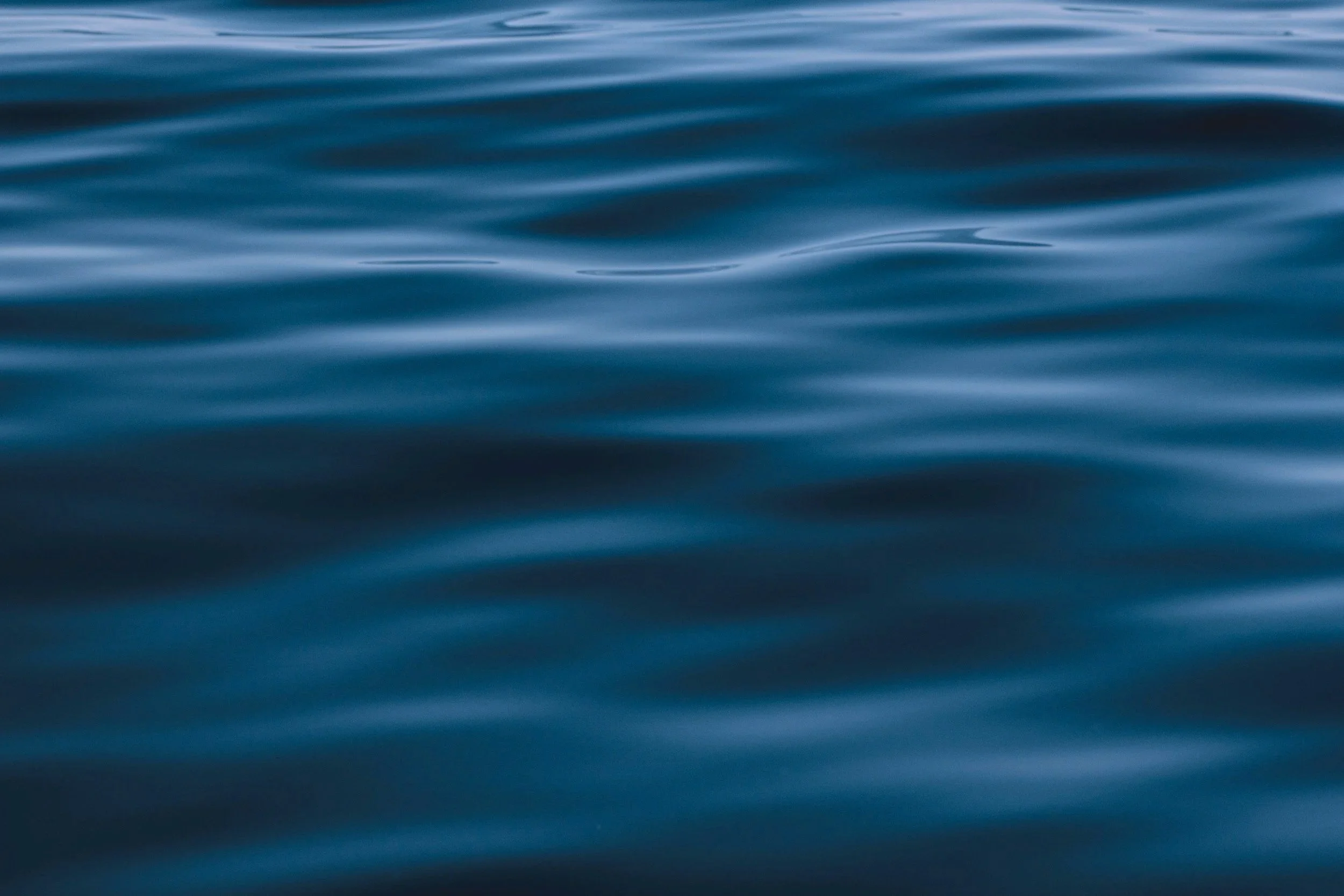Close-up of calm blue water surface with gentle ripples.