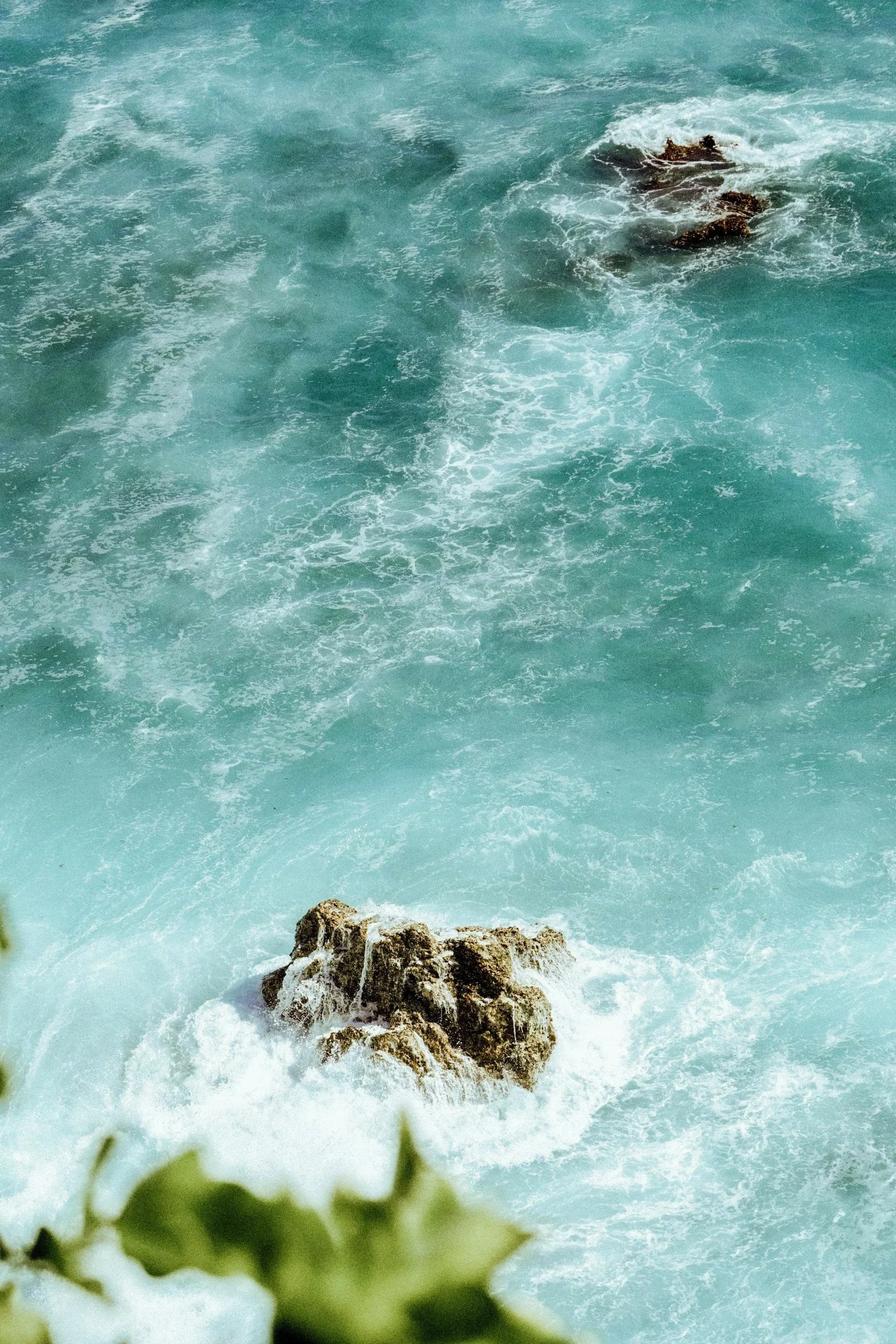 Ocean waves crashing against rocks near the shore.