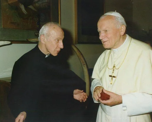 Pope Francis shaking hands with a catholic priest or clergy member.