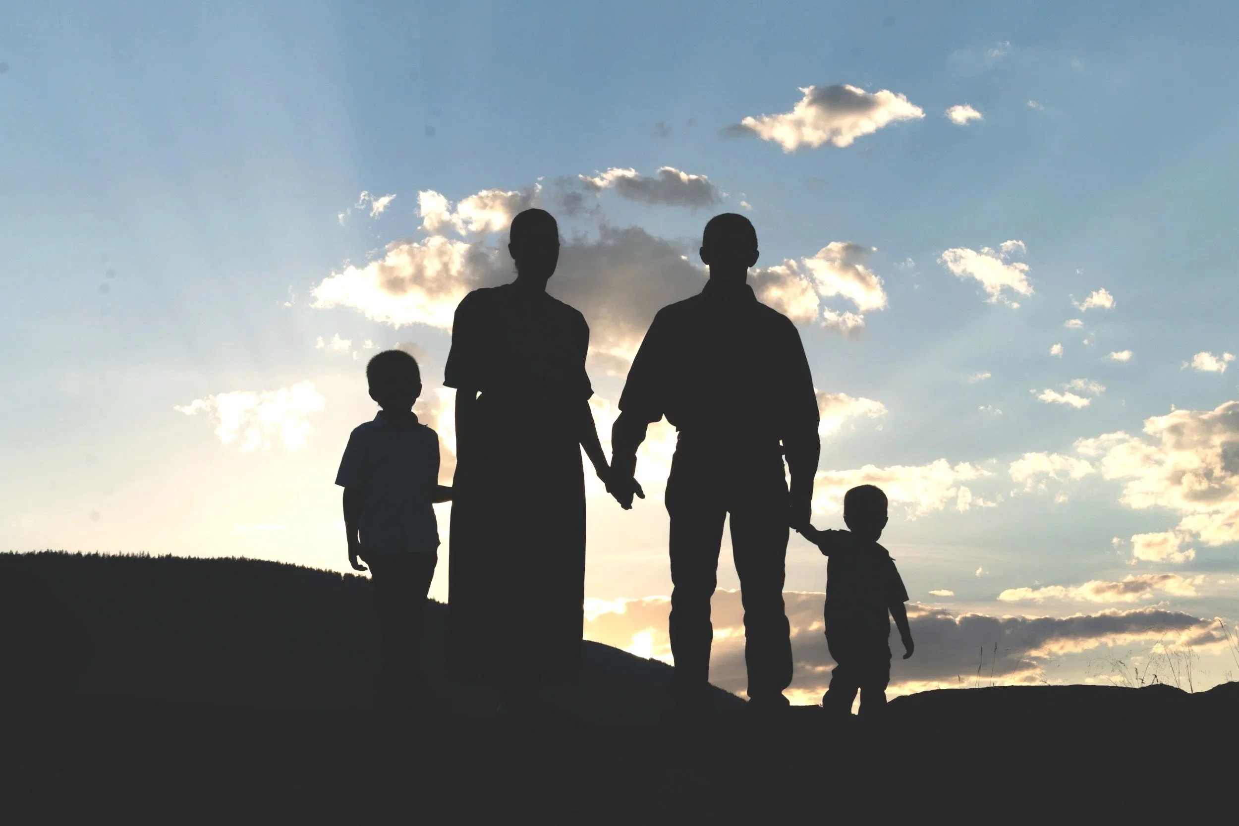 Silhouettes of traditional nuclear family holding hands