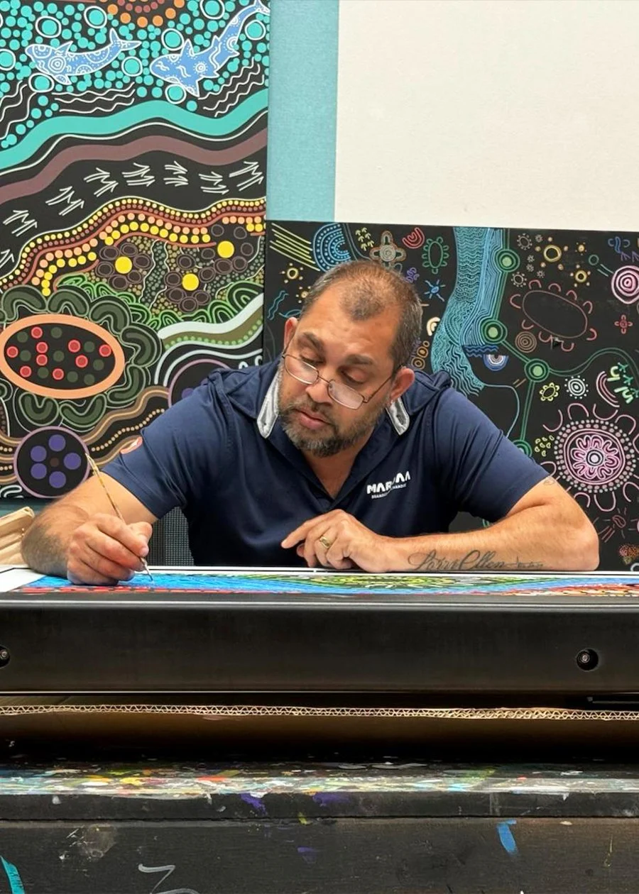 A Mardaa employee painting artwork at his desk