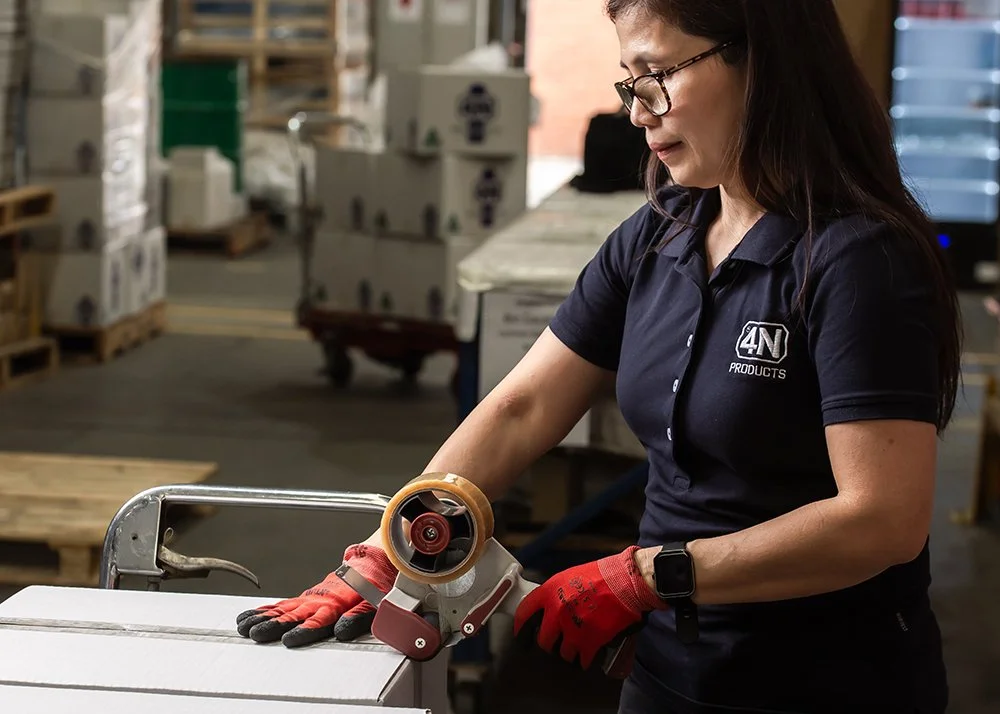 A 4N employee taping up a box