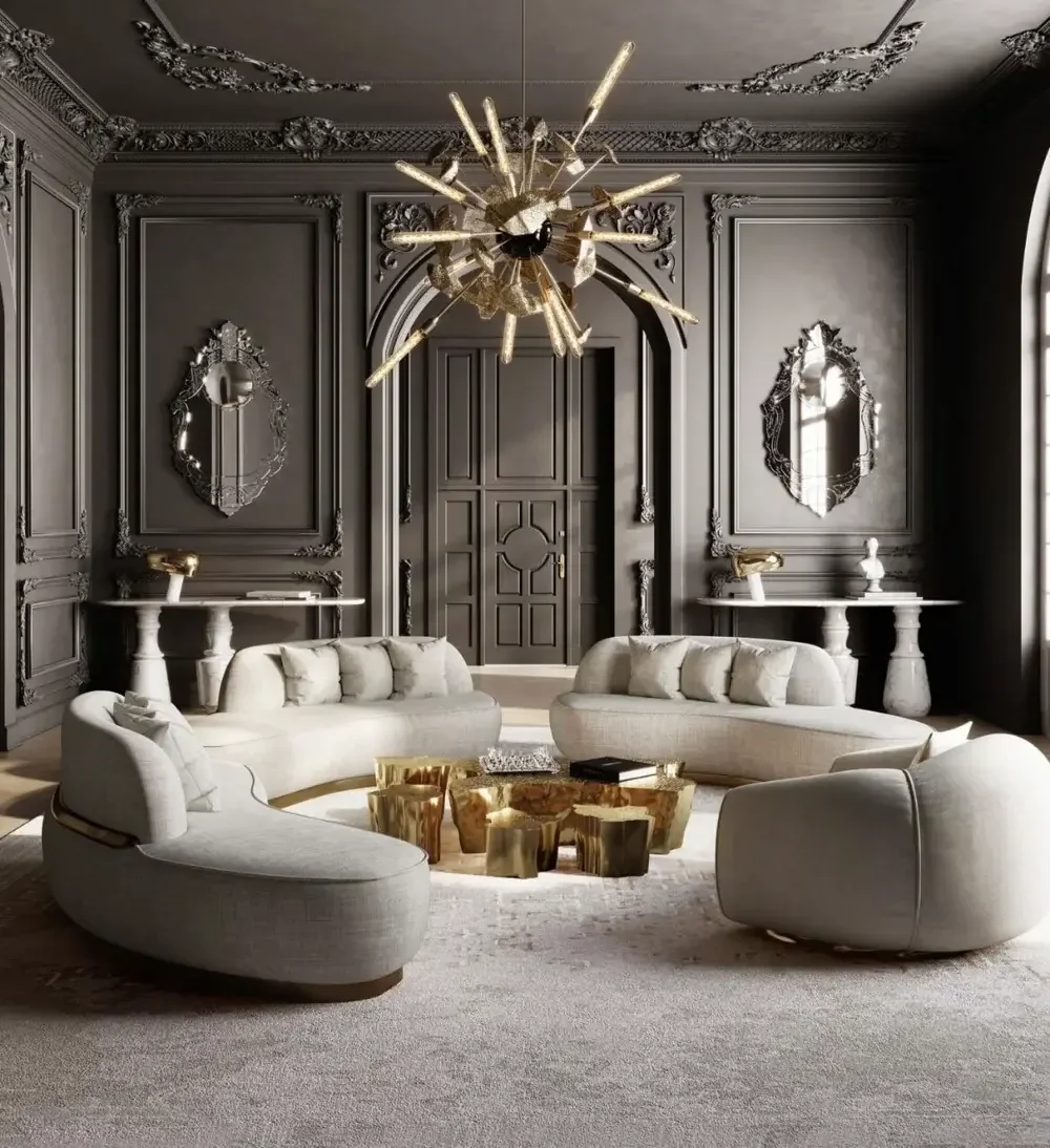 Luxurious living room with gray paneled walls, ornate mirrors, modern sofas, and a gold chandelier.