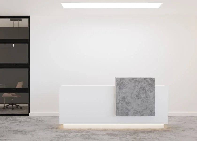 Modern minimalist office reception desk with a concrete square decor piece, white walls, and a glass office on the left side.