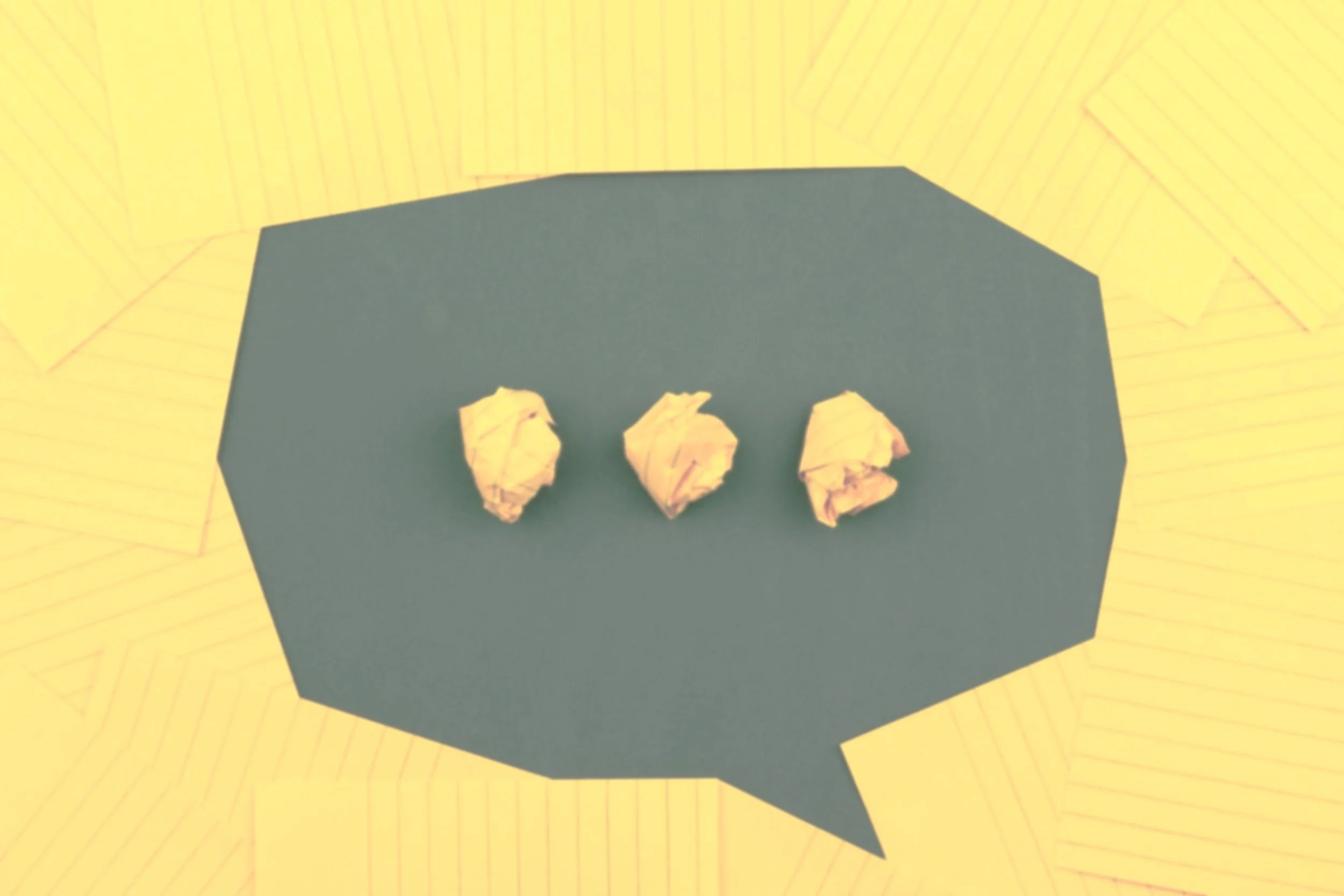 Three crumpled pieces of paper on a blue speech bubble-shaped surface, with a yellow zigzag-patterned background.