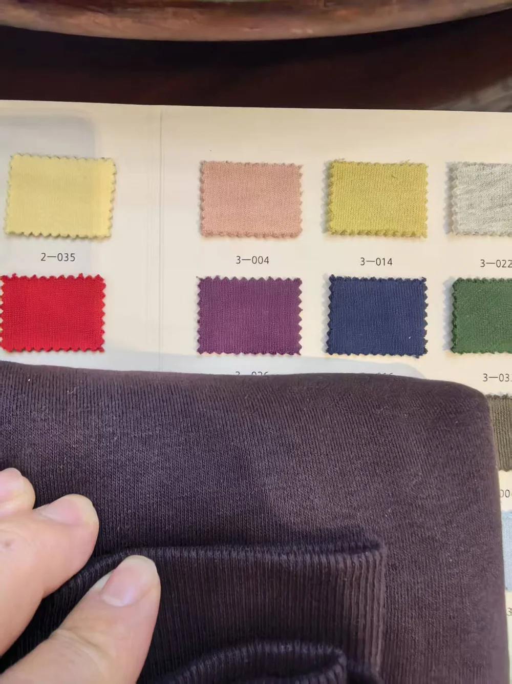 Close-up comparison of garment fabric with selected colour swatches