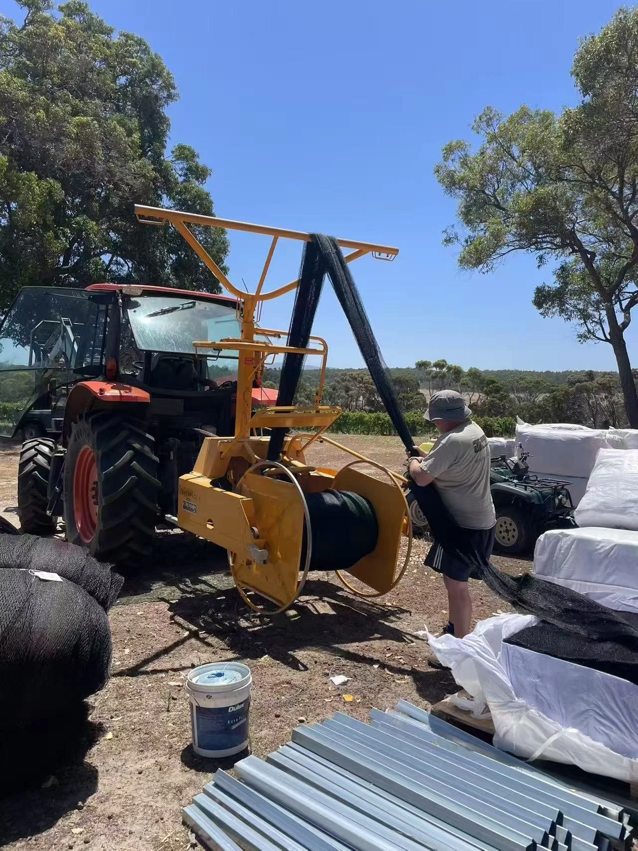 Vineyard bird netting roll being deployed with agricultural machinery