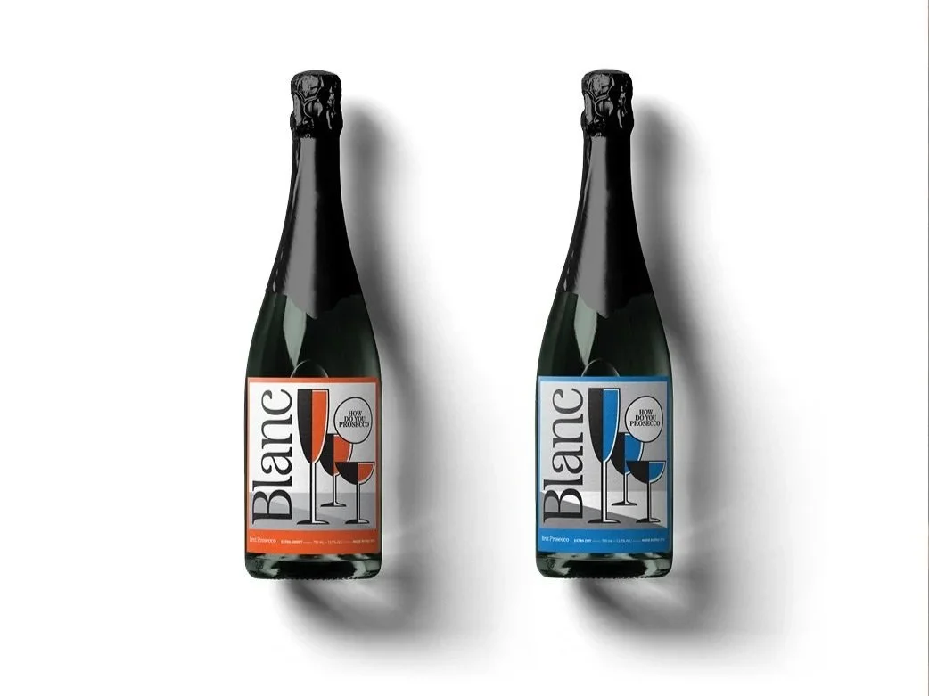 Two bottles of sparkling wine labeled Blanc, one with orange accents and the other with blue accents, against a white background.
