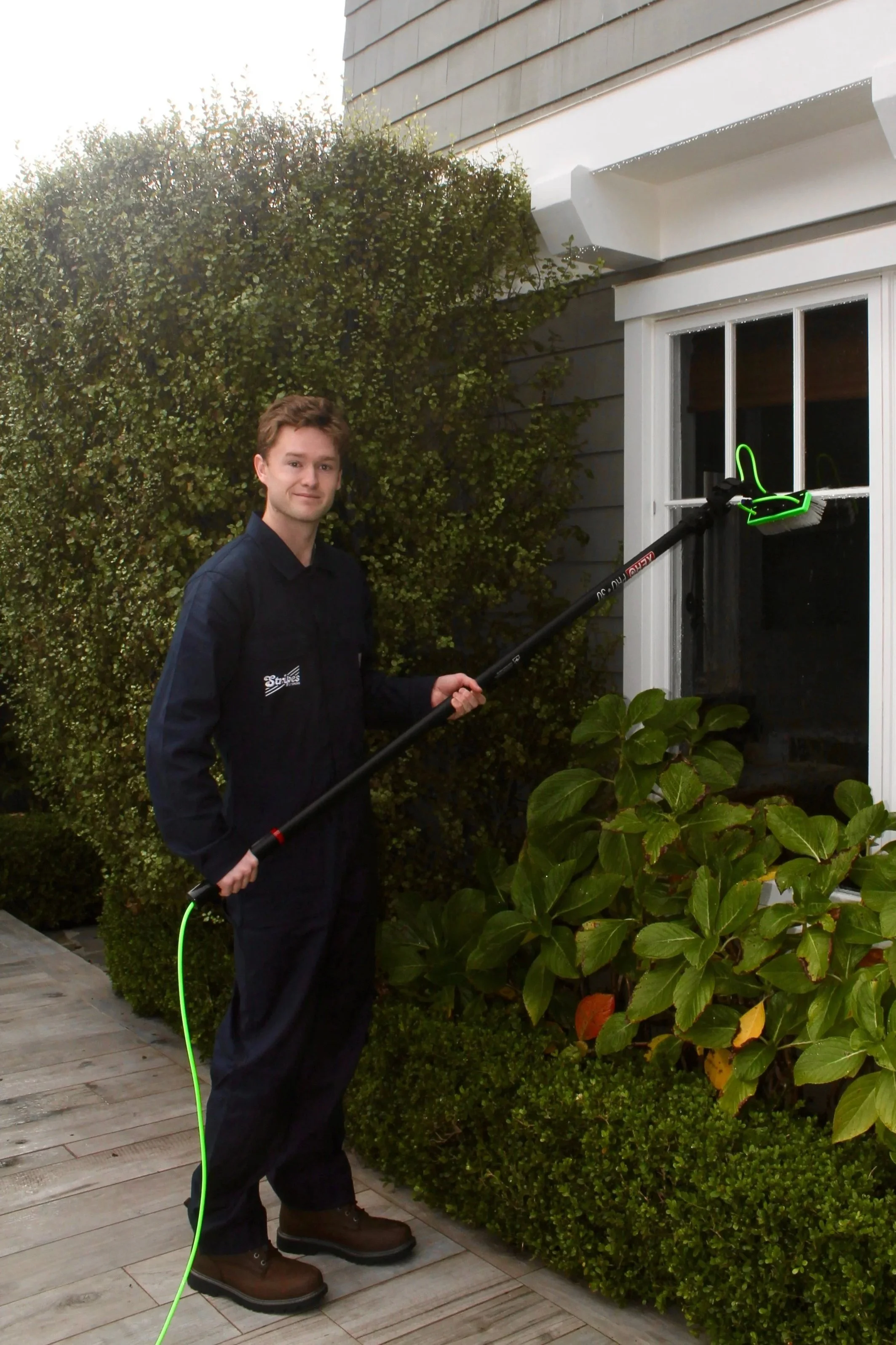 A man cleaning a window with a XERO Pure System.