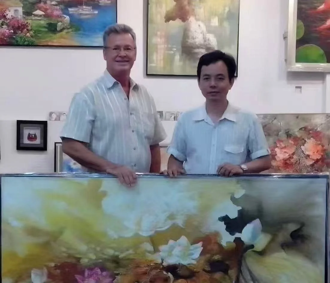 Two men standing behind a large painting of flowers and aquatic plants at an art gallery.