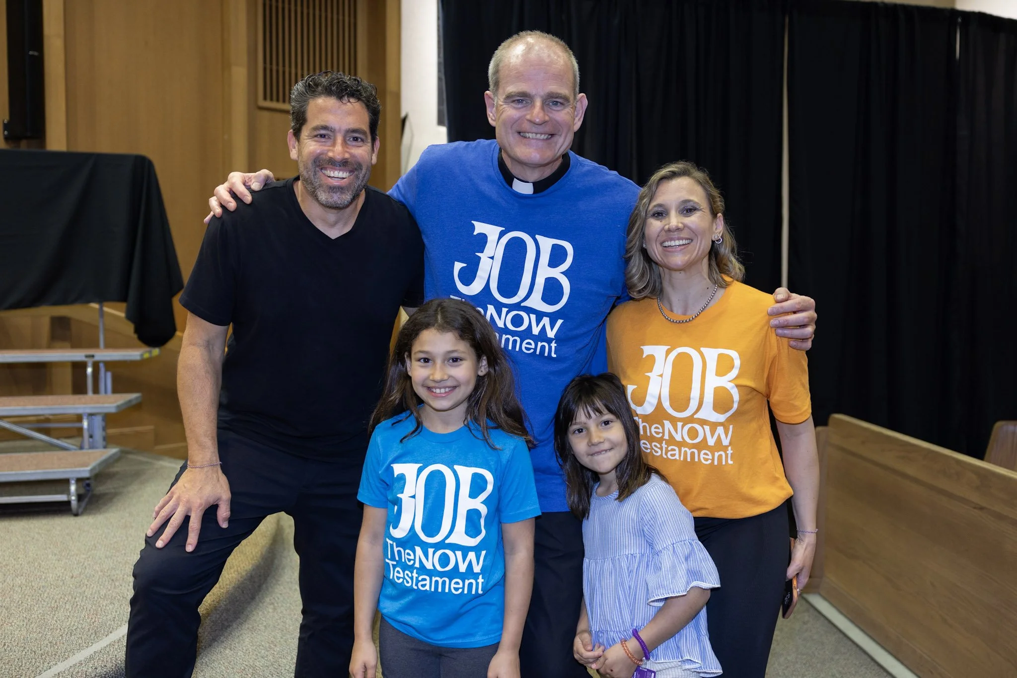 Group wearing shirts with the text 'JOB The Now Testament'.