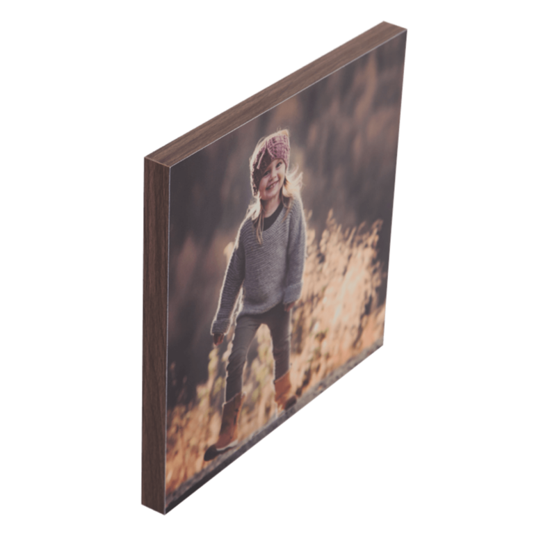 Et foto av en smilende jente i utendørs høstmiljø, iført genser og lue.