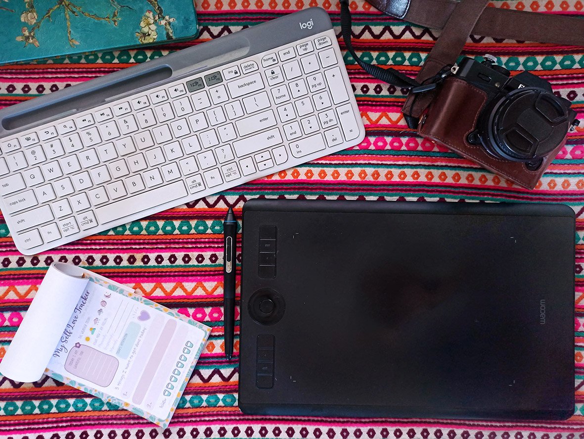 Some of my essentials: Wacom, Wireless Keyboard, Camera, Daily Planner, and Notebook.