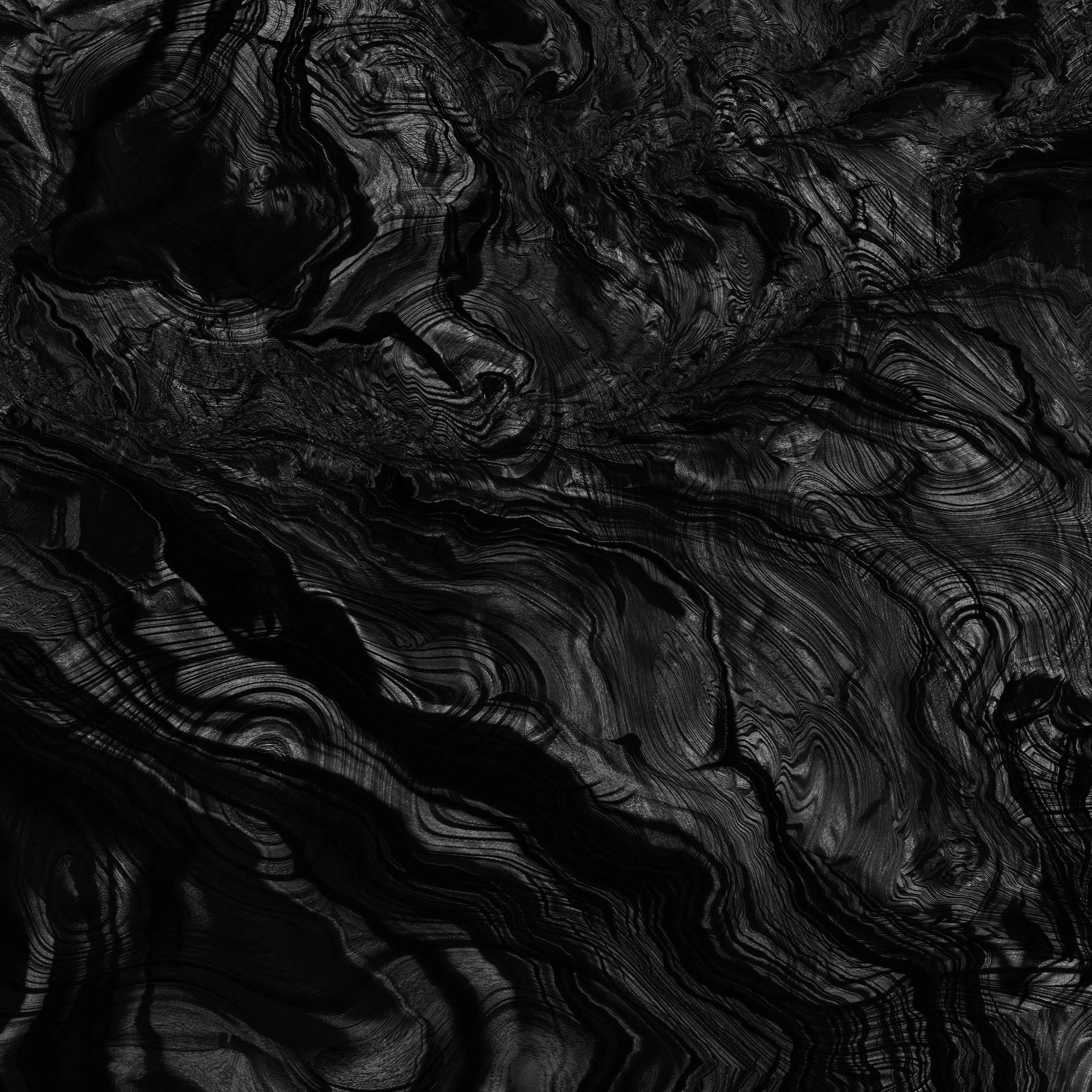 Close-up of a black and gray patterned surface, possibly a piece of marble or wood with swirling lines and intricate details.