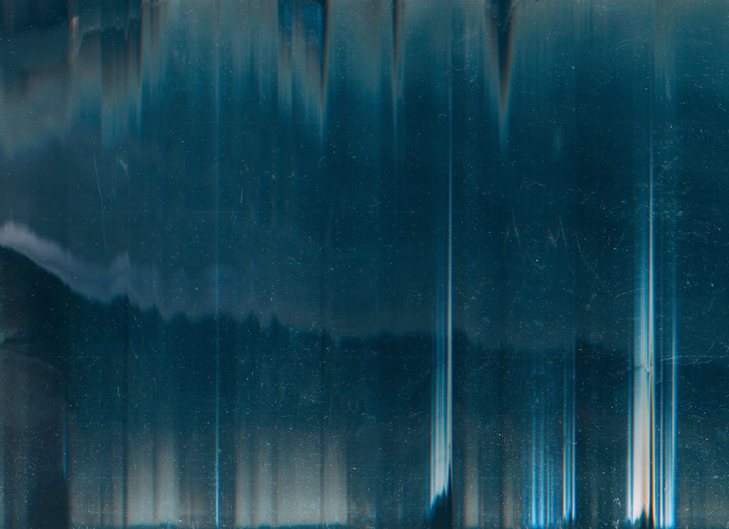 Close-up of a metallic surface with vertical streaks of light and dark blue colors, showing a textured and reflective appearance.