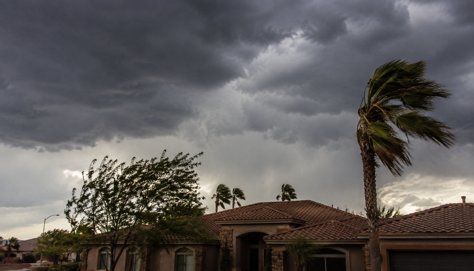 Monsoon storm clouds over a Las Vegas home with a tile roof.