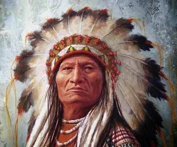 A Native American man wearing a traditional feather headdress with a serious expression.