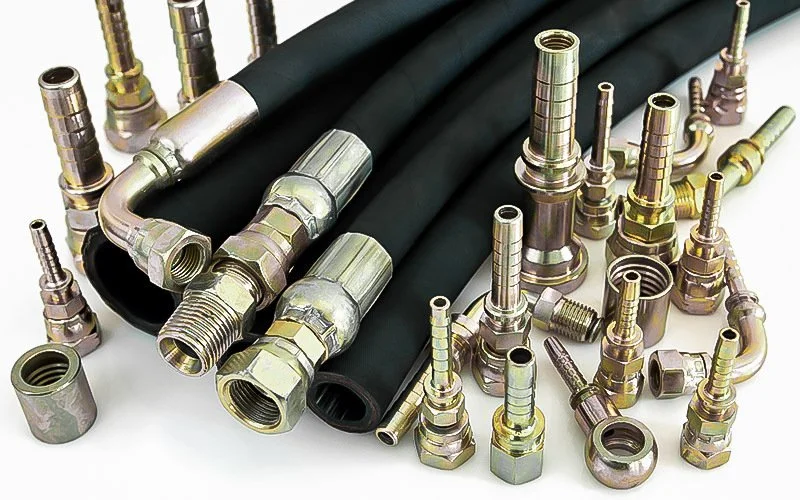 Various black hoses and brass fittings and connectors on a white surface.