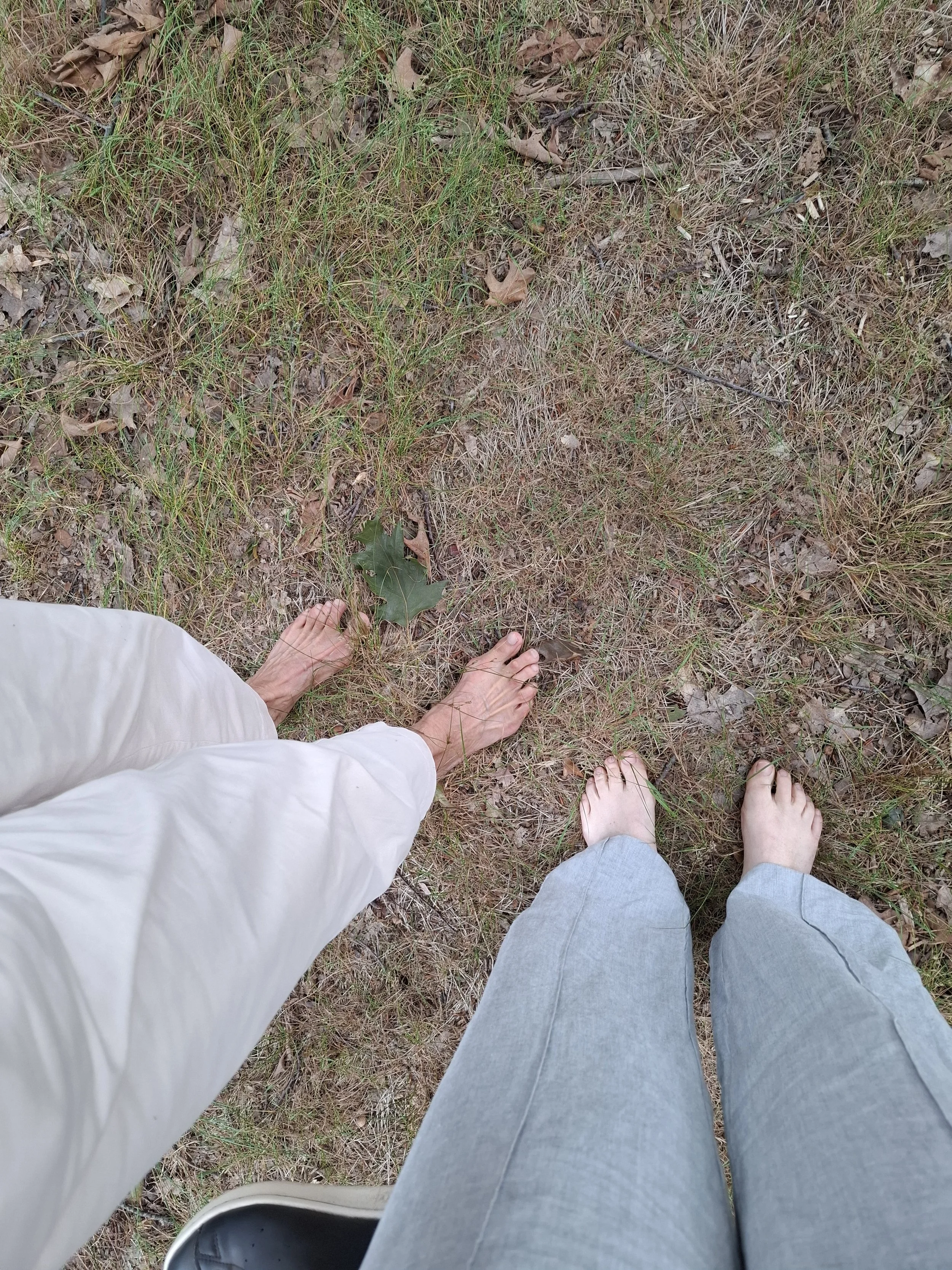 Marieke natuurcoach en deelnemer staan op bosgrond met blote voeten.