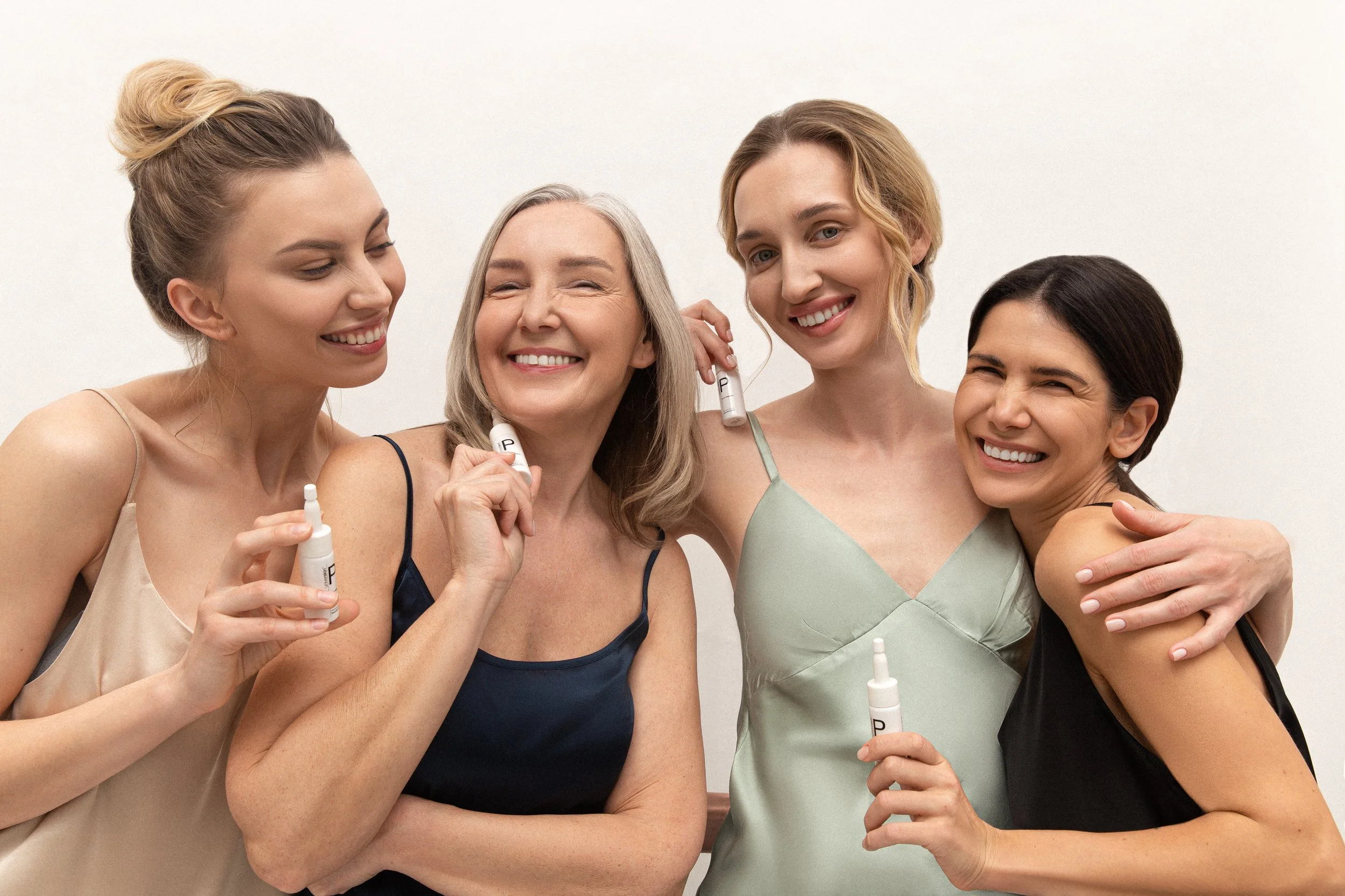 Four women holding customised serums