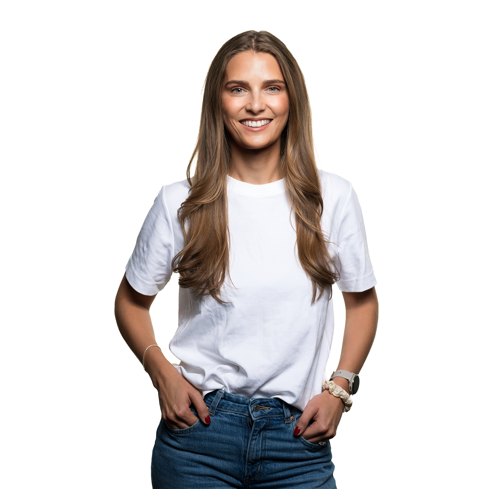 A young woman with long brown hair smiling, wearing a white T-shirt, blue jeans, and a watch, standing against a background with black and yellow sections.