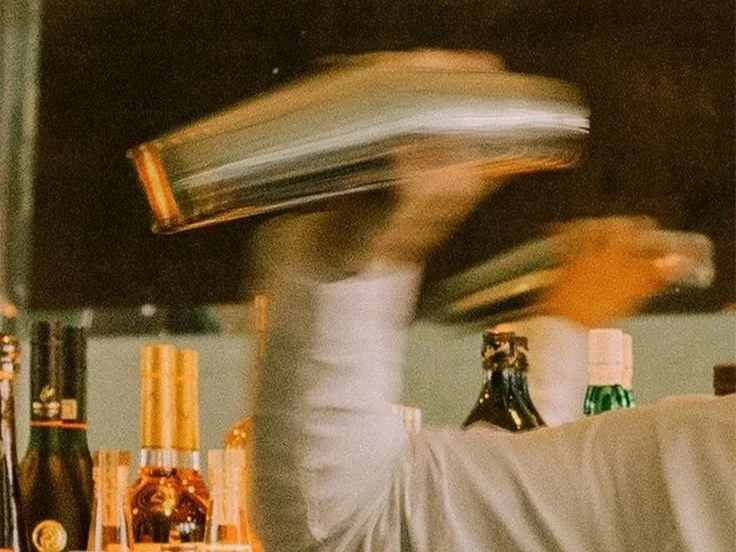 Bartender mixing cocktails, representing craftsmanship, hospitality, and the art of creating experience in service branding.